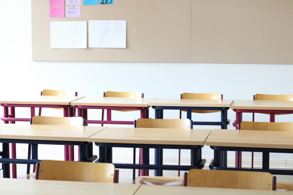 pexels-photo-12168811-12168811 A bright, empty classroom in Einbeck, Deutschland, featuring wooden desks and chairs.